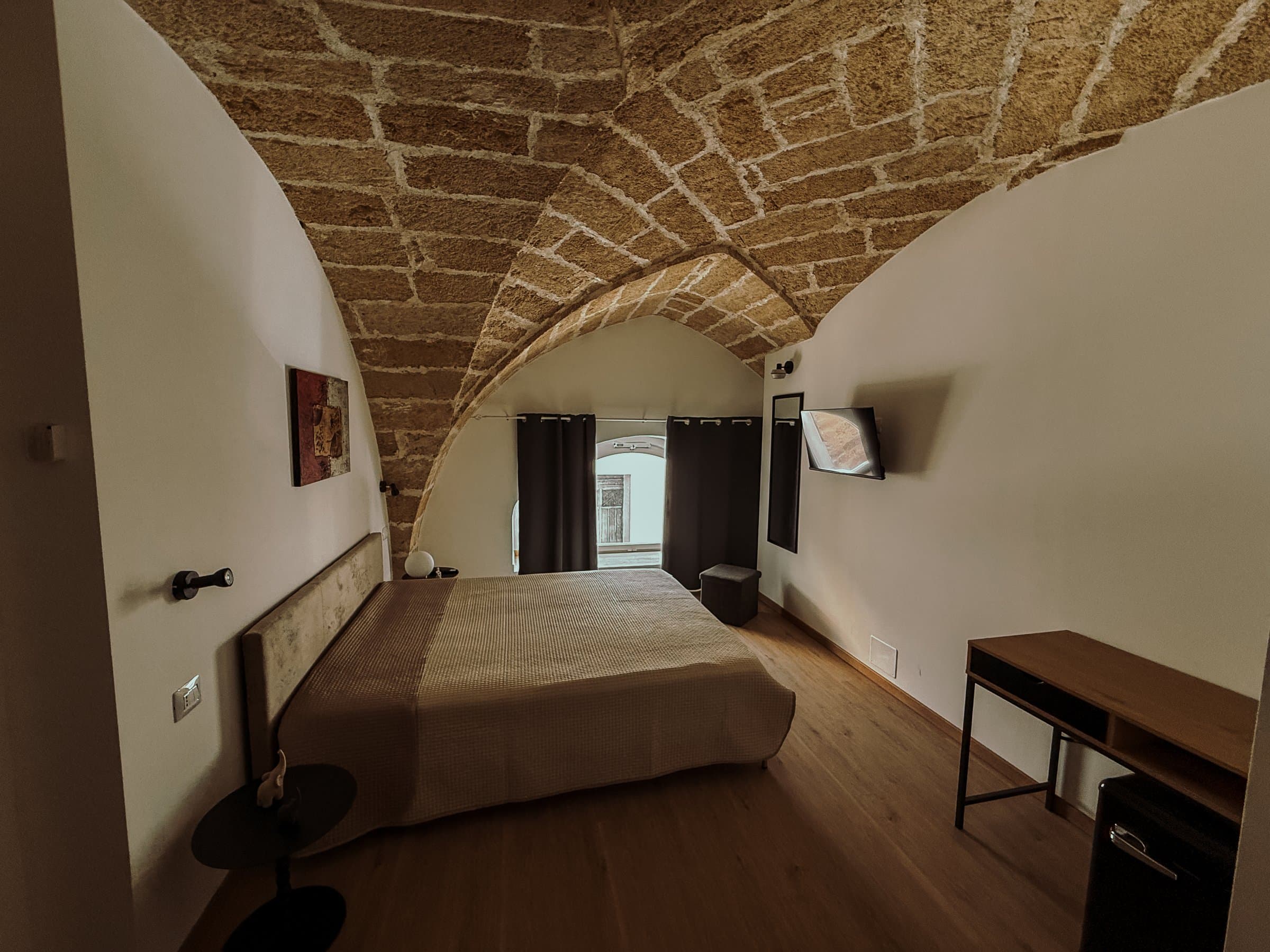 Camera con letto matrimoniale, TV e finestra con tende