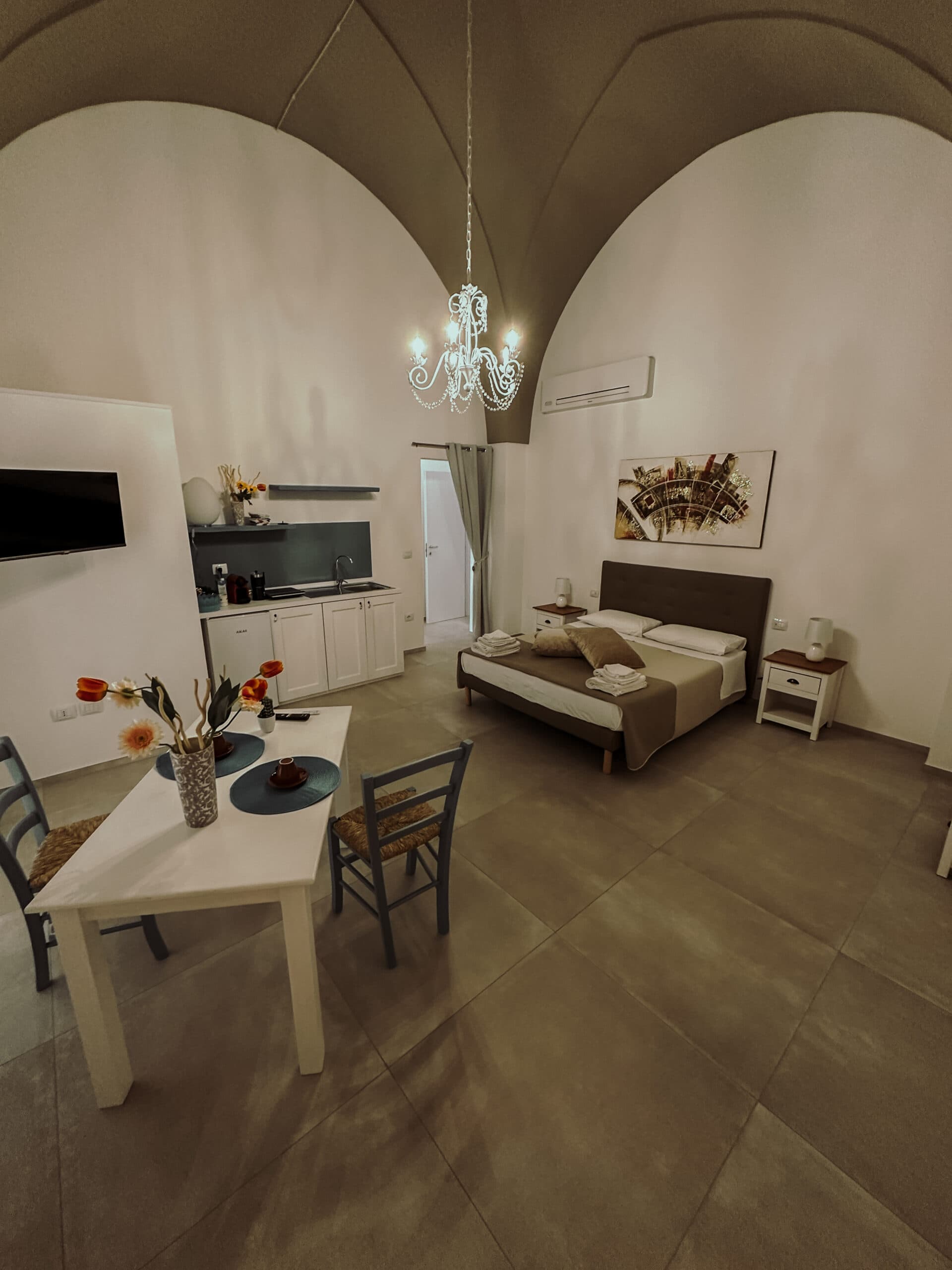 Room with double bed, dining area and vaulted ceiling